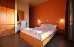 a bedroom with a bed with two towels on it at Eucalyptus Villa in Aegina Town +25 photos