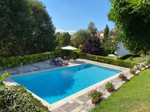 a swimming pool in a yard next to a garden at Da Zoe in Moncalvo