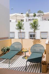 2 stoelen en een tafel op een balkon bij Pasaje Zamora Apartamentos in Sevilla