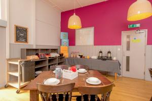 a kitchen with a table and chairs and a purple wall at YHA Blaxhall in Blaxhall