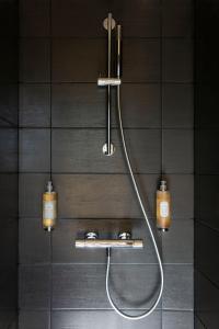 a shower in a bathroom with two lights on the wall at Hôtel 48°Nord & Restaurant, The Originals Relais in Breitenbach