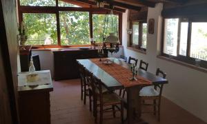a dining room with a table and chairs and windows at Casa Cuculo - Rustico mit traumhaftem Meerblick in Scansano