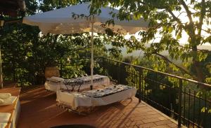two beds on a balcony with an umbrella at Casa Cuculo - Rustico mit traumhaftem Meerblick in Scansano