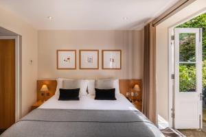 a bedroom with a large white bed with two pillows at The Resident Kensington in London