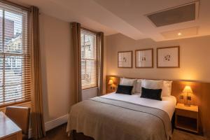 a bedroom with a white bed with two pillows at The Resident Kensington in London