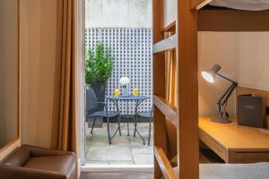 um quarto com vista para uma mesa e um quarto com uma varanda em The Resident Kensington em Londres