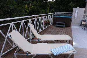 two white chairs on a deck with a hot tub at Luxury Fani House Next to Harbor area with Jacuzzi in Paphos