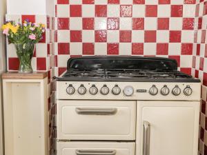 a white stove in a kitchen with a vase of flowers at Ryeby Garth in Hull