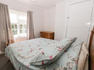 a bedroom with a bed with a floral bedspread at Ryeby Garth in Hull