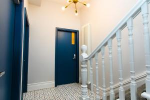 a blue door in a hallway with stairs at Stay Coastal in Whitley Bay