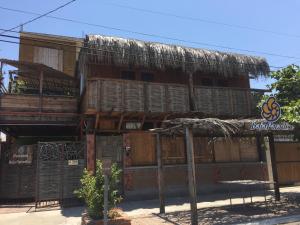 un edificio antiguo con techo de paja en Pension Baja Paradise, en La Paz