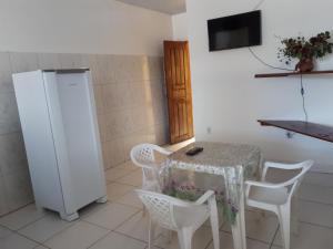 uma cozinha com uma mesa e cadeiras e um frigorífico em Casa para temporada em Belém