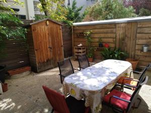 un patio con mesa, sillas y una valla en cosy rare 2 bedroom apartment around a private garden, en Neuilly-sur-Seine