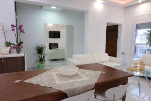 a living room with a wooden table and white chairs at Luxury Fani House Next to Harbor area with Jacuzzi in Paphos