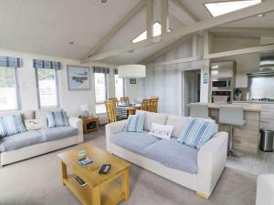 ein Wohnzimmer mit 2 Sofas und einer Küche in der Unterkunft 44 Heritage Park in Narberth