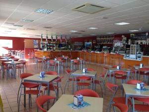 a restaurant with tables and chairs in a room at Hostal Ayamonte Los Mellizos in Ayamonte