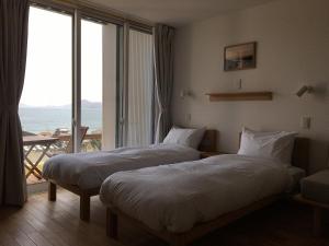 Duas camas num quarto de hotel com varanda em MY LODGE Naoshima em Naoshima