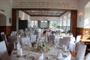 a room filled with tables and chairs with white tablecloths at Hotel Restaurant Schlössli Sax in Sax