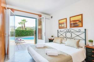 a bedroom with a large bed and a pool at Villa SOFIA in Cala en Forcat +6 photos