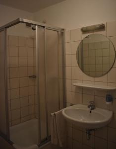a bathroom with a shower and a sink and a mirror at Hotel Restaurant Meints4you im Bürgerhof in Recklinghausen
