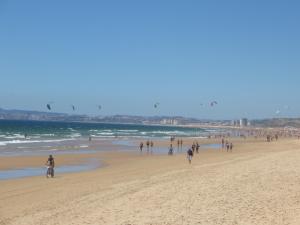 a group of people walking on the beach at Caparica for Rent in Costa da Caparica