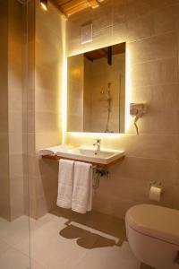 W łazience znajduje się umywalka, toaleta i lustro. w obiekcie Grand Boutique Hotel w Prisztinie