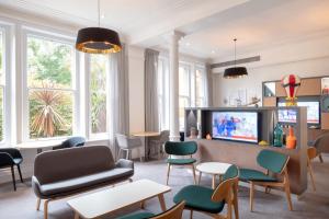 uma sala de estar com mobiliário e uma televisão e janelas em Holiday Inn Farnborough, an IHG Hotel em Farnborough