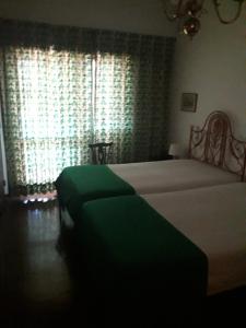 een slaapkamer met een groot bed en een raam bij Caparica for Rent in Costa da Caparica