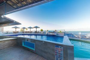 a large swimming pool with tables and umbrellas at Flat Pipa's Bay in Pipa