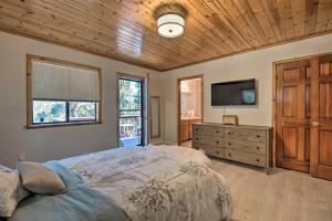 1 dormitorio con 1 cama y TV de pantalla plana en Cozy Pine Mountain Cabin Hike, Bike, Fish Nearby!, en Pine Mountain Club