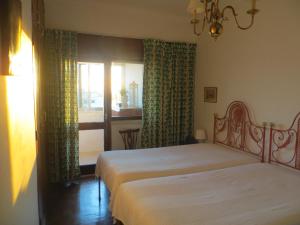 a bedroom with two beds and a window at Caparica for Rent in Costa da Caparica