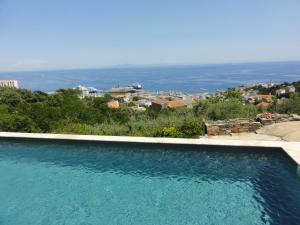 a swimming pool with a view of the ocean at Chambre Élégante Lisa in Bastia