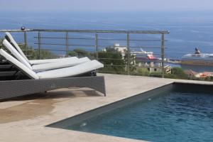 a pool with chairs and a cruise ship in the water at Chambre Élégante Lisa in Bastia