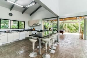 an open kitchen with white cabinets and a black countertop at Casa Cariblanco in Tarcoles