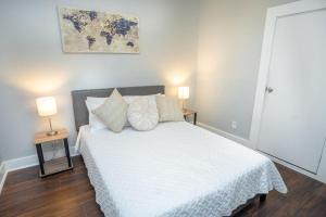 a bedroom with a large white bed with two lamps at Remodeled Historic 1BR 1BA House Near Downtown in San Antonio