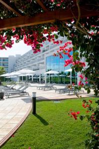 un edificio con mesas de picnic y flores en un parque en Vista Marina Apartamentos Turisticos, en Portimão