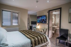 a bedroom with a bed and a desk and a bathroom at Hotel 21 in Southport