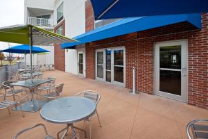 a patio area with tables, chairs and umbrellas at Holiday Inn Express Fishers - Indy's Uptown, an IHG Hotel in Fishers