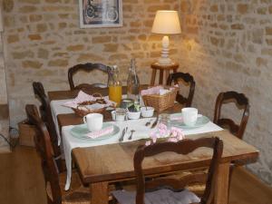 une table à manger avec une nappe blanche et une nappe dans l'établissement Le Tamaris Chambres d'hôtes, à Sainte-Hermine