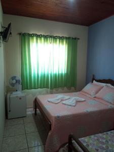 een slaapkamer met 2 bedden en een groen gordijn bij Aconchego do céu in Conceição da Ibitipoca