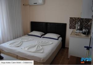 a bedroom with a bed with a black headboard at Cane Motel in Avşa Adası