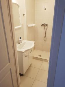 een witte badkamer met een wastafel en een douche bij Apartament 4 Central in Târgu-Mureş