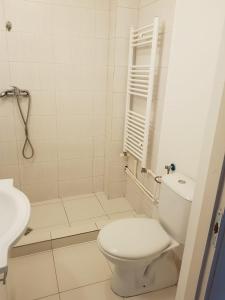 a white bathroom with a toilet and a sink at Apartament 4 Central in Târgu-Mureş
