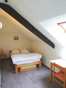 蓬提維的住宿－Auberge de Jeunesse HI Pontivy，一间卧室配有一张床和一张木桌