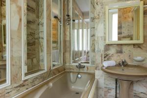 a bathroom with a tub and a sink and a bath tub at Hotel Belle Isle Sur Risle in Pont-Audemer