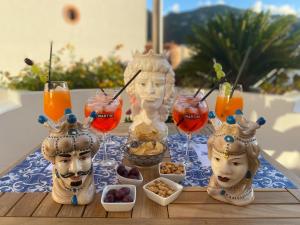 un tavolo con due statue di teste con bevande e cibo di Diana Brown B&B Affittacamere a Città di Lipari