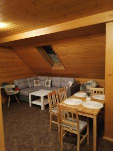 a living room with a couch and a table and chairs at Apartament Harenda in Zakopane