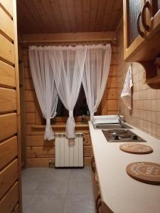 a kitchen with a stove and a window at Apartament Harenda in Zakopane