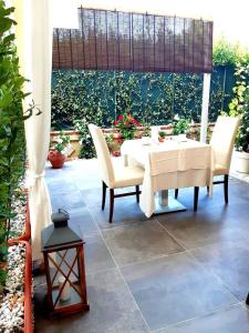 un tavolo bianco e sedie su un patio di Hotel Giardino a Lido di Camaiore
