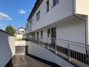 balkon w białym budynku z poręczą w obiekcie Apartment SCHLADMING - Neualm center w Schladming